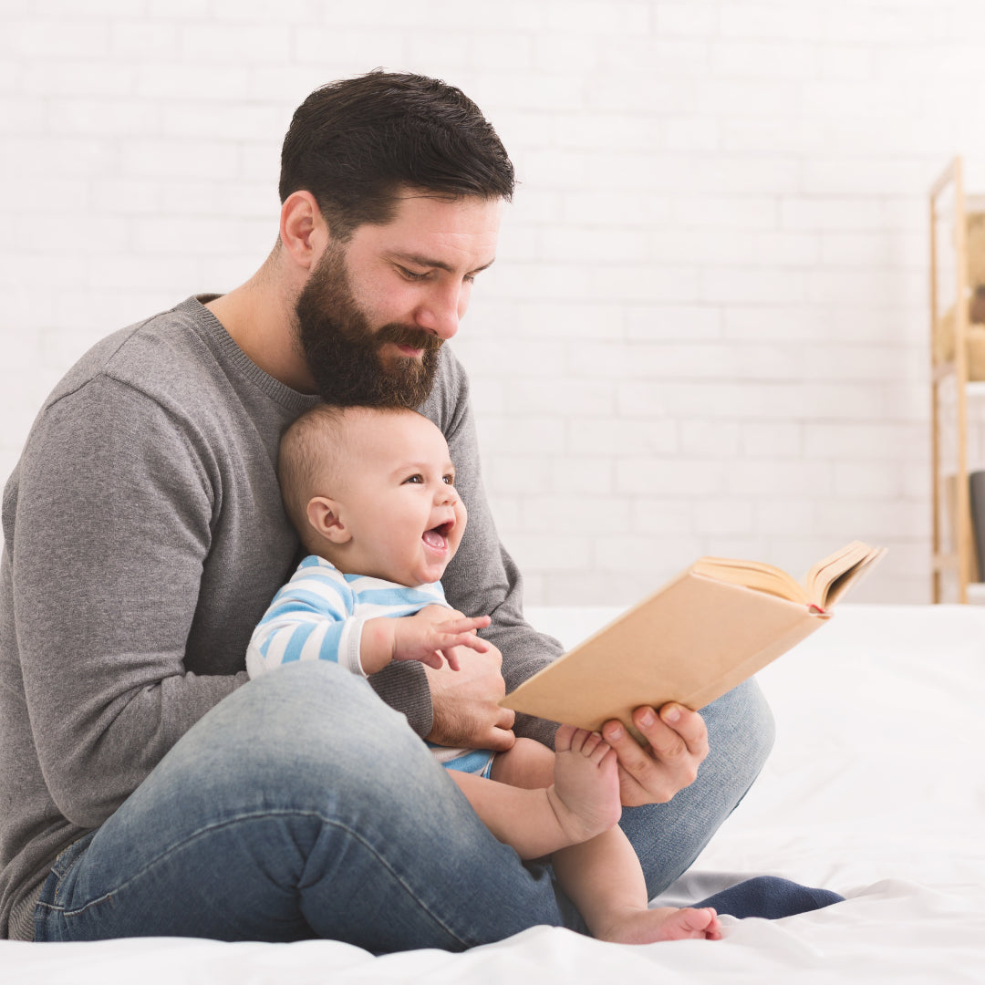 Baby laughing while dad reads a story