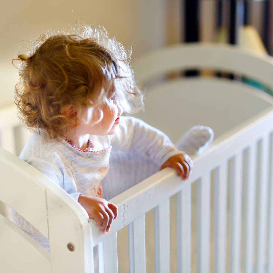 Toddler climbing out of their cot